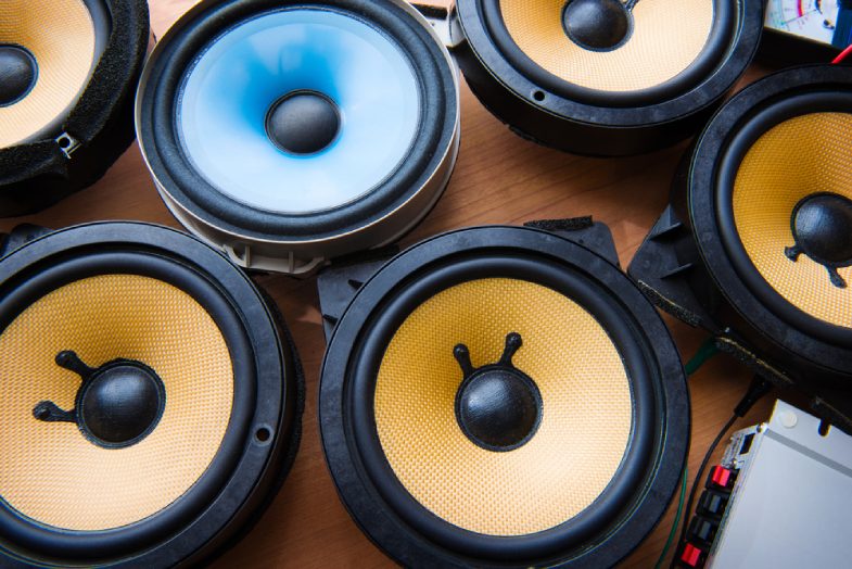 Car audio speakers on a work table.
