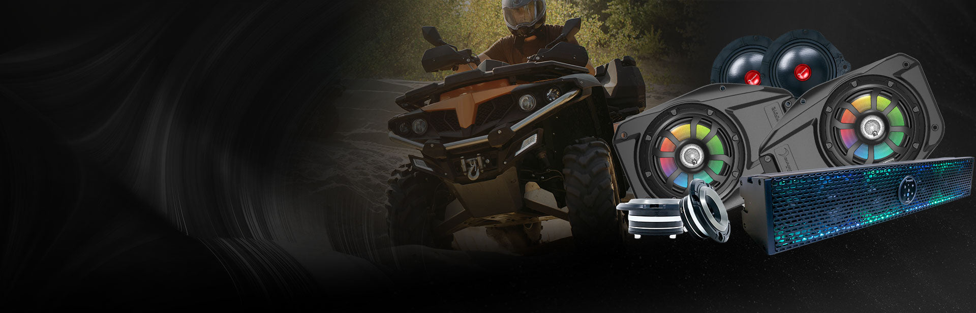 ATV rider in full gear with sound system equipment in the foreground.