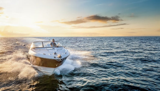 A motorboat moves toward the camera with the setting sun in the background.